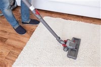 Vacuuming white carpet using the vacuum cleaner