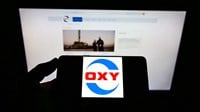 mobile phone with logo of US company Occidental Petroleum Corporation (OXY) on screen in front of web page